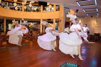 Traditional Mexican folkloric dancers performing in flowing white dresses on polished wooden floor at Playa Los Arcos Puerto Vallarta