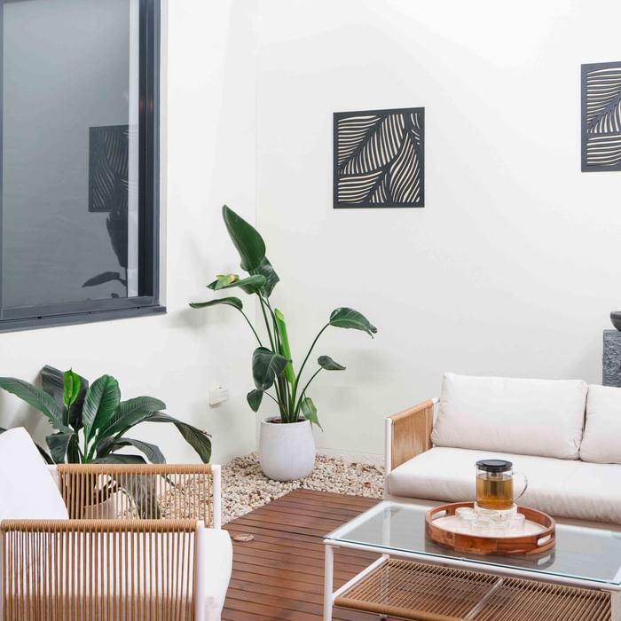 Wildfire Day Spa with white sofa, indoor plants, and abstract wall art at Mercure Kooindah Waters