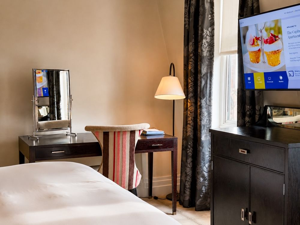 A cozy Townhouse Junior Suite bedroom at The Capital Hotel, Apartments & Townhouse in London.