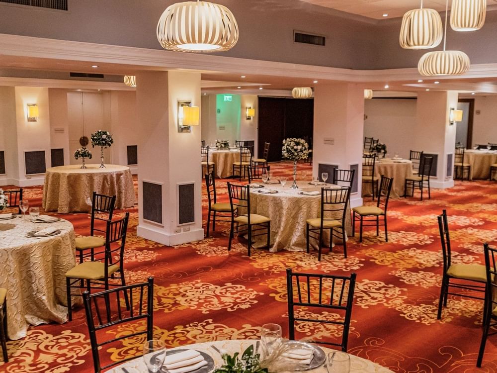 Banquet tables and chairs set for a wedding in Perlas Room at Gamma Hotels