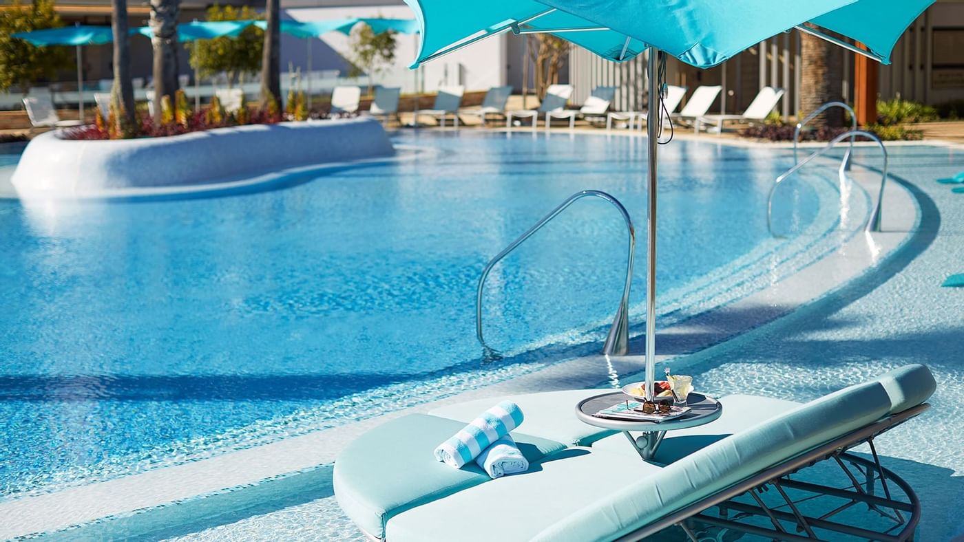 Rolled towels on a sunbed by the pool at Crown Hotels