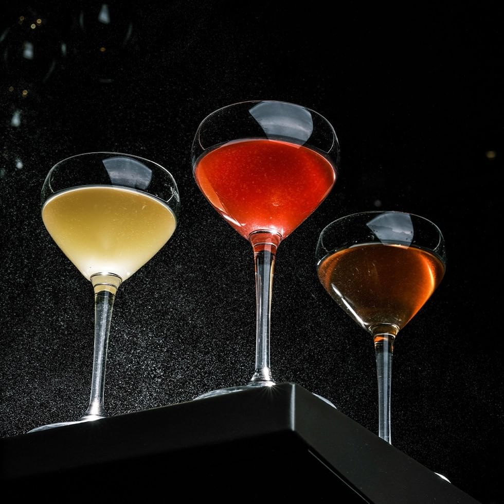 Three fancy glasses filled with different colored drinks promoting Local Spirits Producers Masterclass.