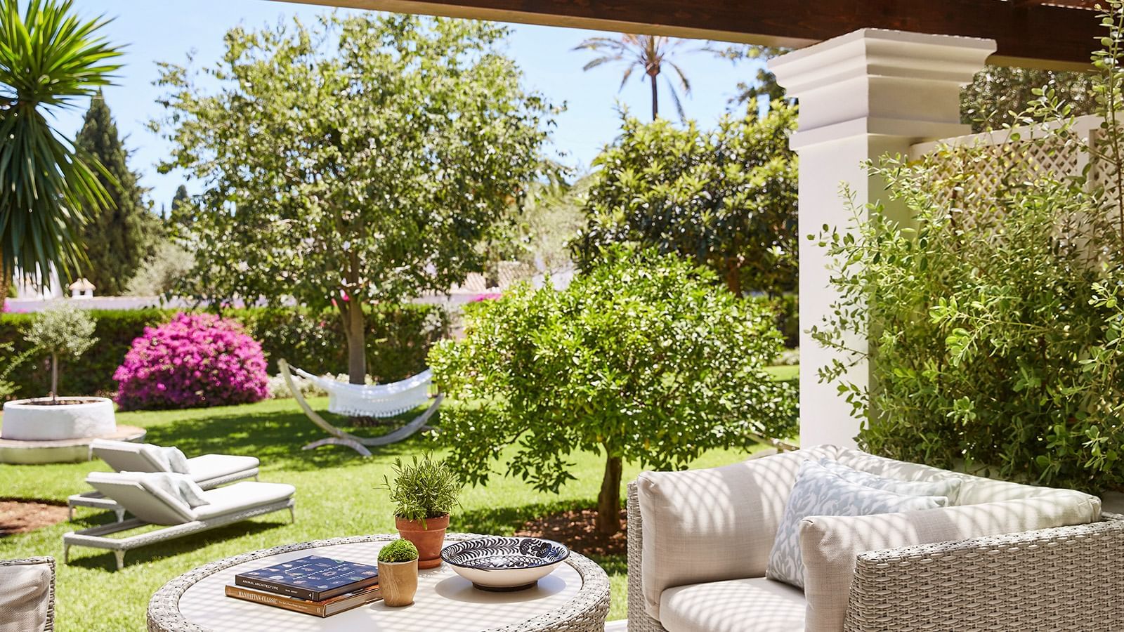 Junior Suite Deluxe terrace overlooking a manicured lawn with bougainvillea and a small hammock at Marbella Club