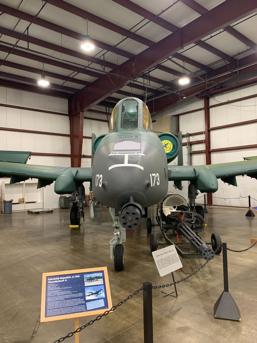Military jet aircraft on display inside the hangar museum beside the Gatling gun display stand near Avon Old Farms Hotel