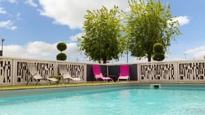 View of pool loungers from the outdoor pool at Originals Hotels