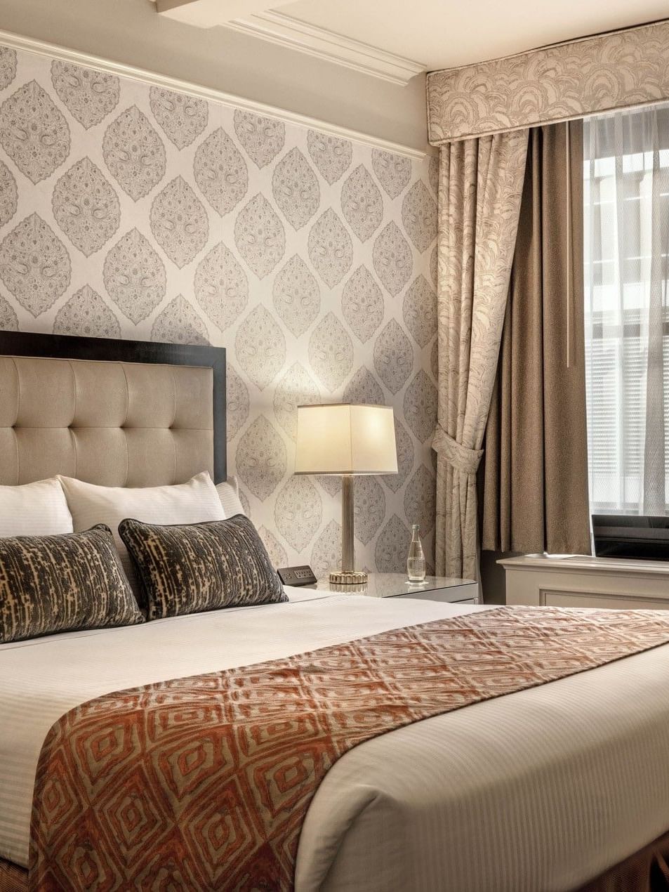 Bed with side table near window in Accessible On the Avenue Suite at Warwick New York