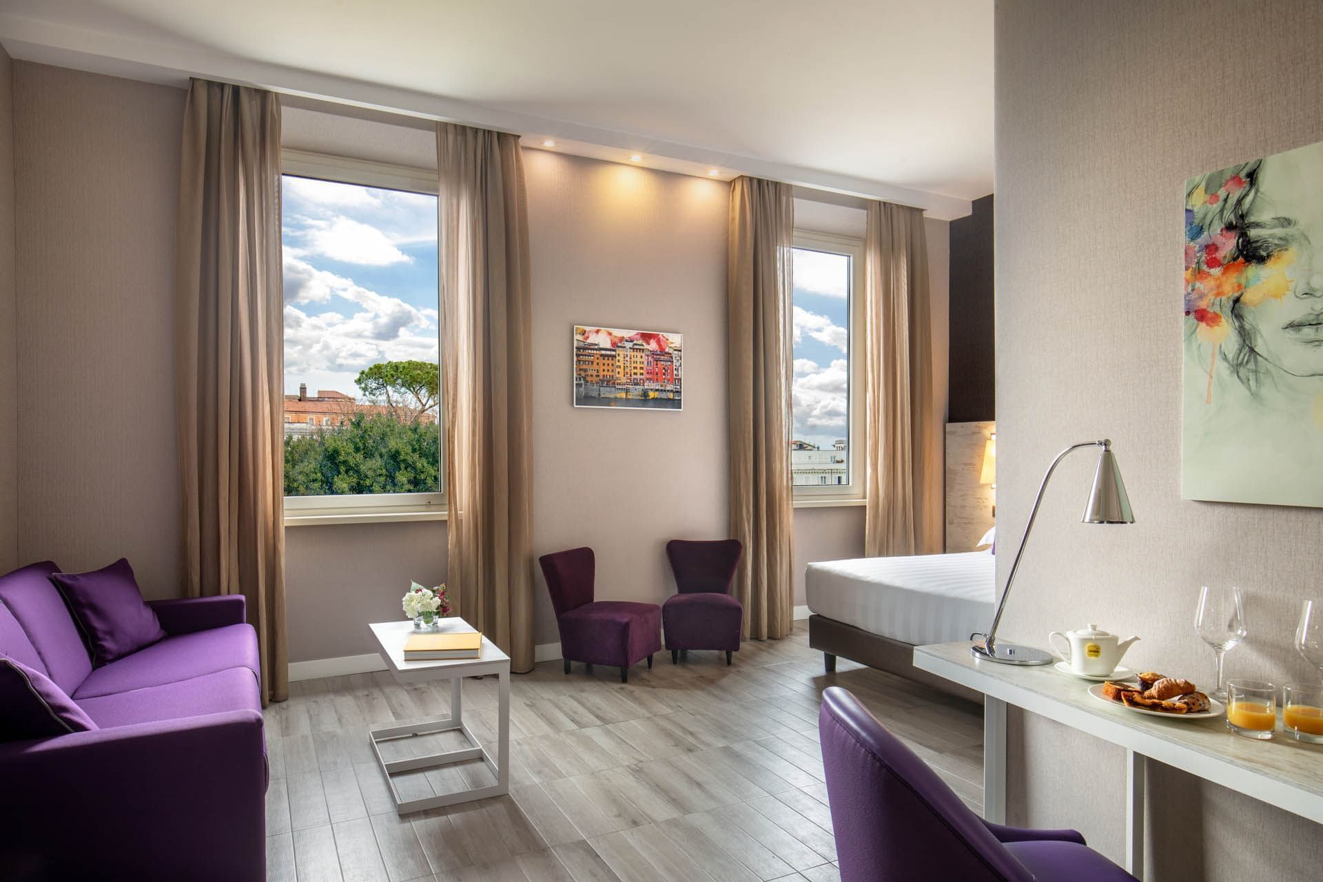 Stylish Family Room with purple chairs, a white table, and large windows framing the outside view at The Guardian Hotel