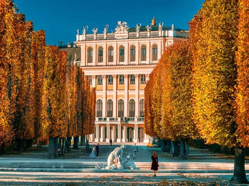 Herbstliche Allee vor Schloss Schönbrunn in Wien.