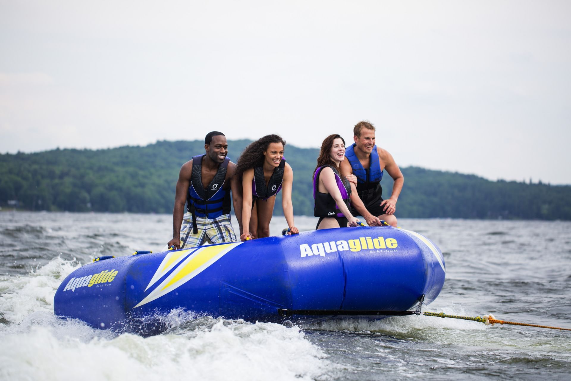 A group of four people enjoys a thrilling ride on a boat on a serene lake near Cove Pocono Resorts