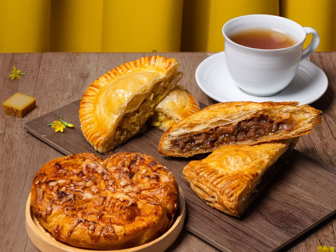 A tray of delicious pastries accompanied by a steaming cup of tea. A delightful treat for any time of the day.