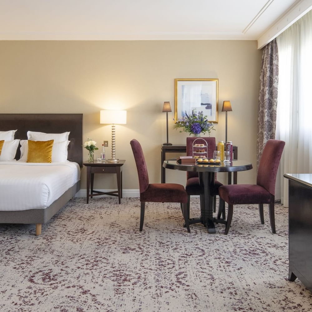 Une chambre Junior Suite à la décoration élégante et dotée d'un lit douillet au Warwick Champs-Élysées Paris.