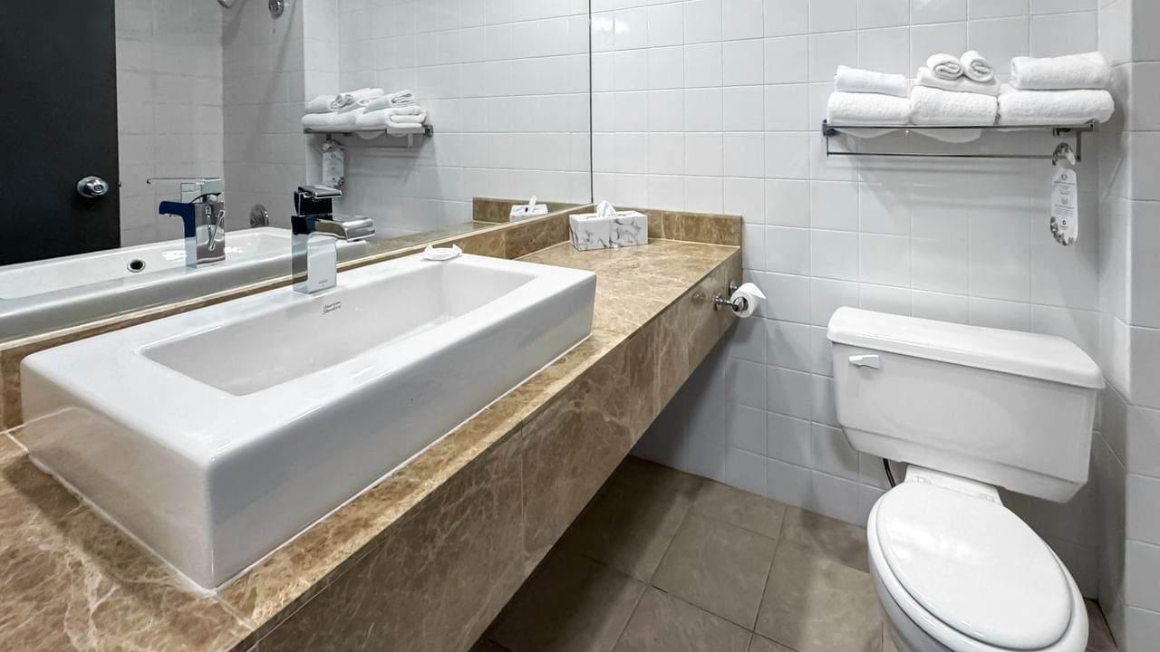 Coast Premium King bathroom with a sink, toilet, and white towels on a rack at Coast Lonsdale Quay Hotel