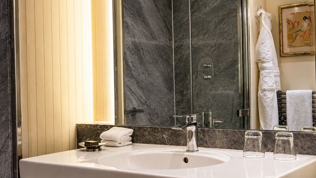 White bathroom sink with silver faucet and towels in the Townhouse Junior Suite at The Capital Hotel London.