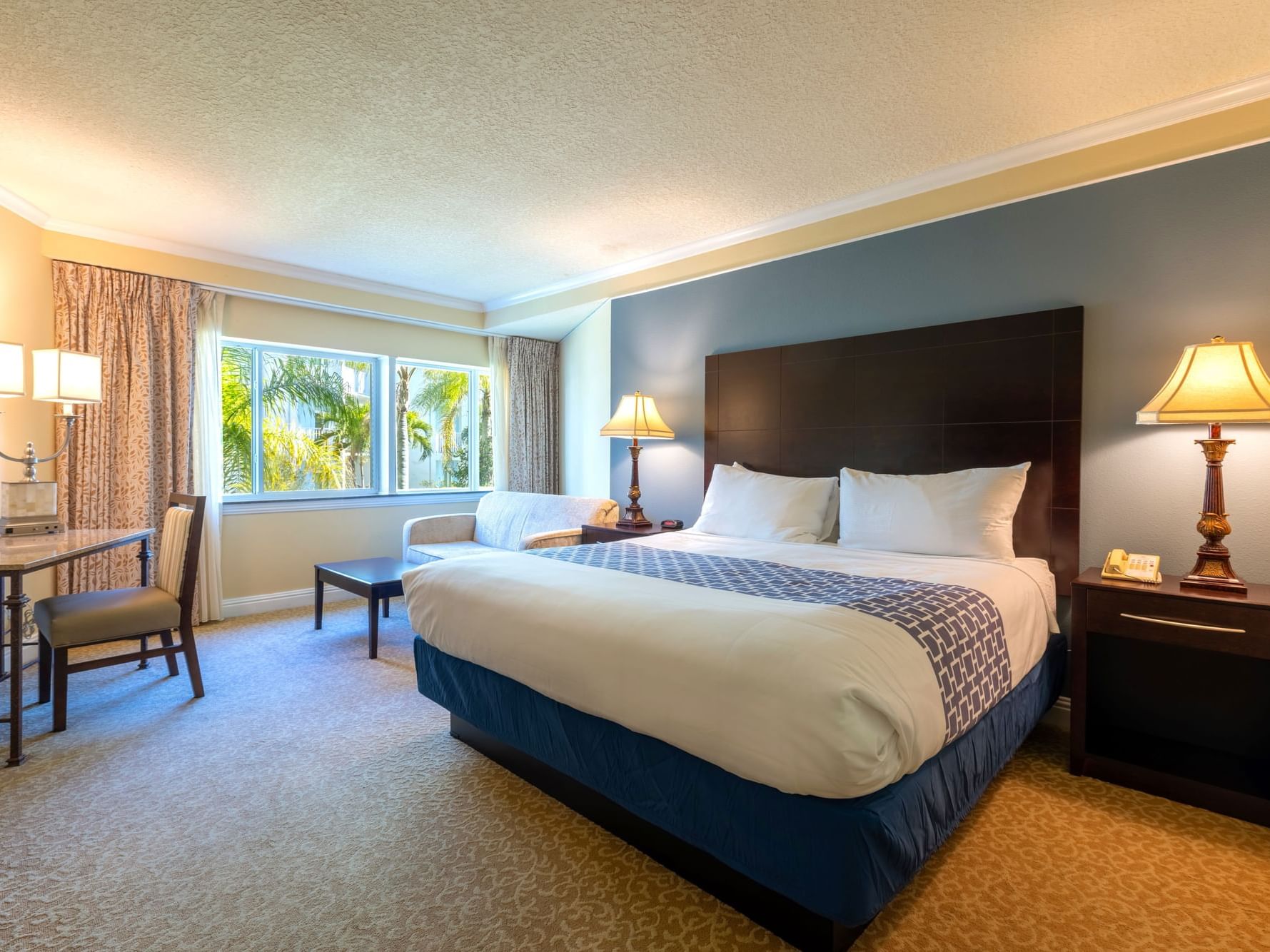 One King Bed hotel room with nightstands, lamps, and couch at the Safety Harbor Hotel in Tampa, FL.
