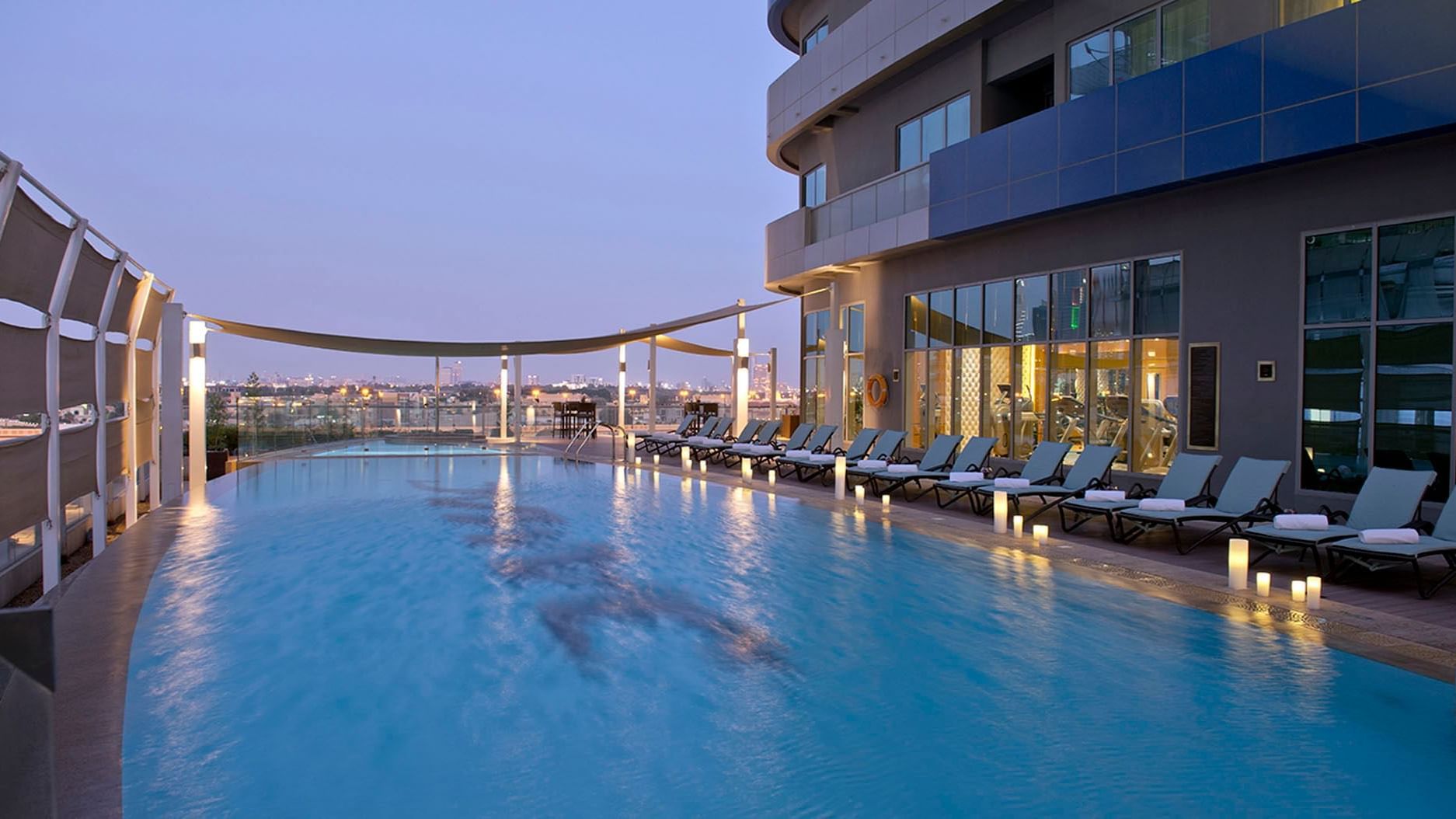 Outdoor pool area with sunbeds and city view at DAMAC Maison Dubai Mall Street