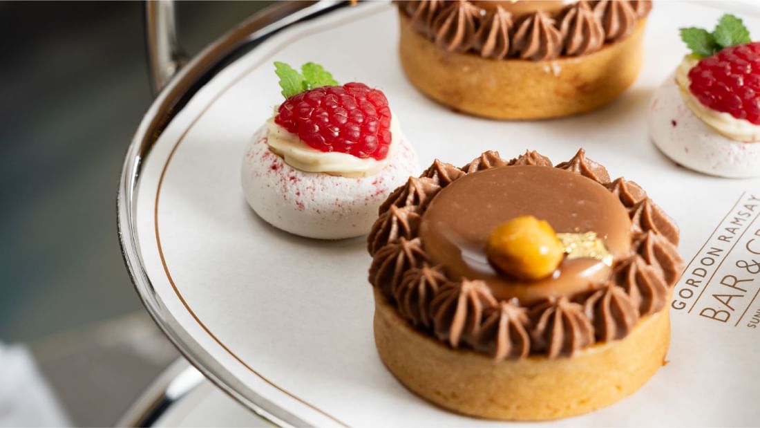 Mini tarts with rich chocolate and light raspberry meringue, elegantly arranged for afternoon tea at Sunway Resort