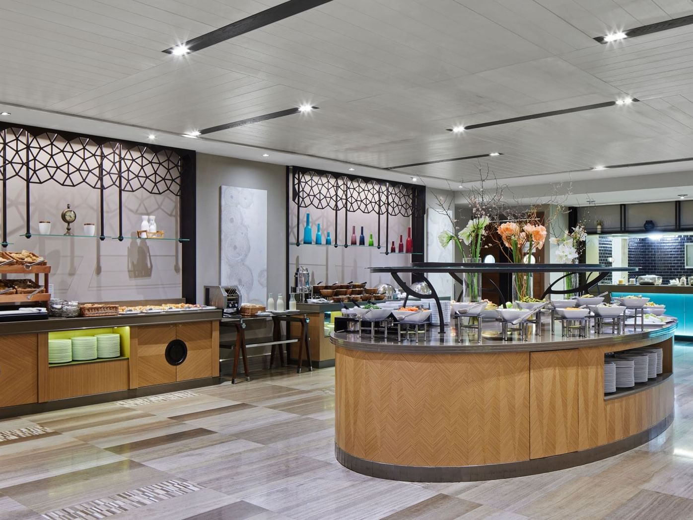 Modernes Restaurant mit Holzboden, stilvollen Trennwänden und runden Theken – Titanic Chaussee Berlin.