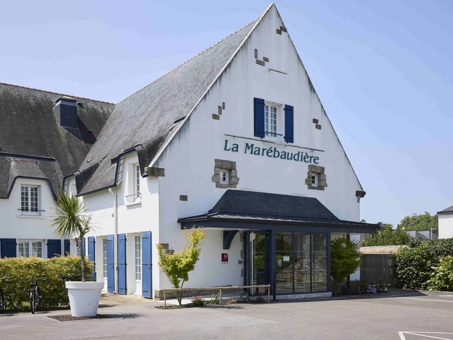 Entrée de l'Hôtel La Marébaudière avec vélos et plantes en pot.