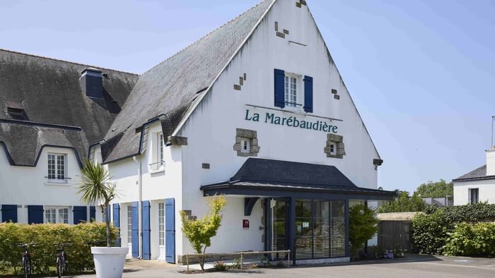 Entrée de l'Hôtel La Marébaudière avec vélos et plantes en pot.