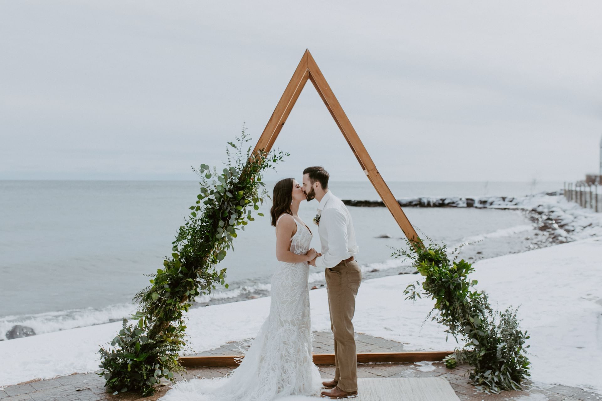 A wedded couple kissing outdoors at Bluefin Bay