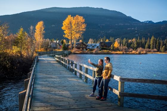 A couple taking a selfie photo on a dock near Blackcomb Springs Suites