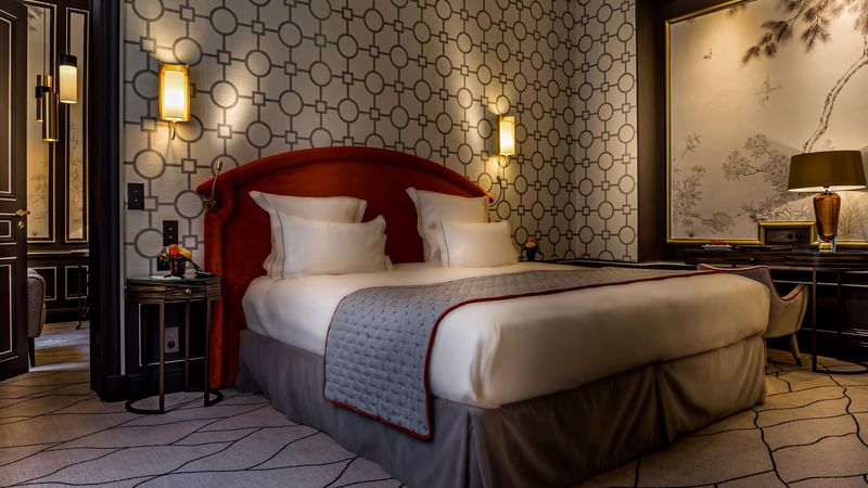 Large bed with warm lighting in Deluxe Parisian suite at Hôtel Westminster - Paris