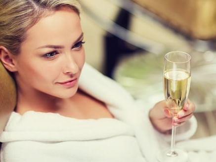 beautiful lady enjoying champagne in robe at Amora Hotel
