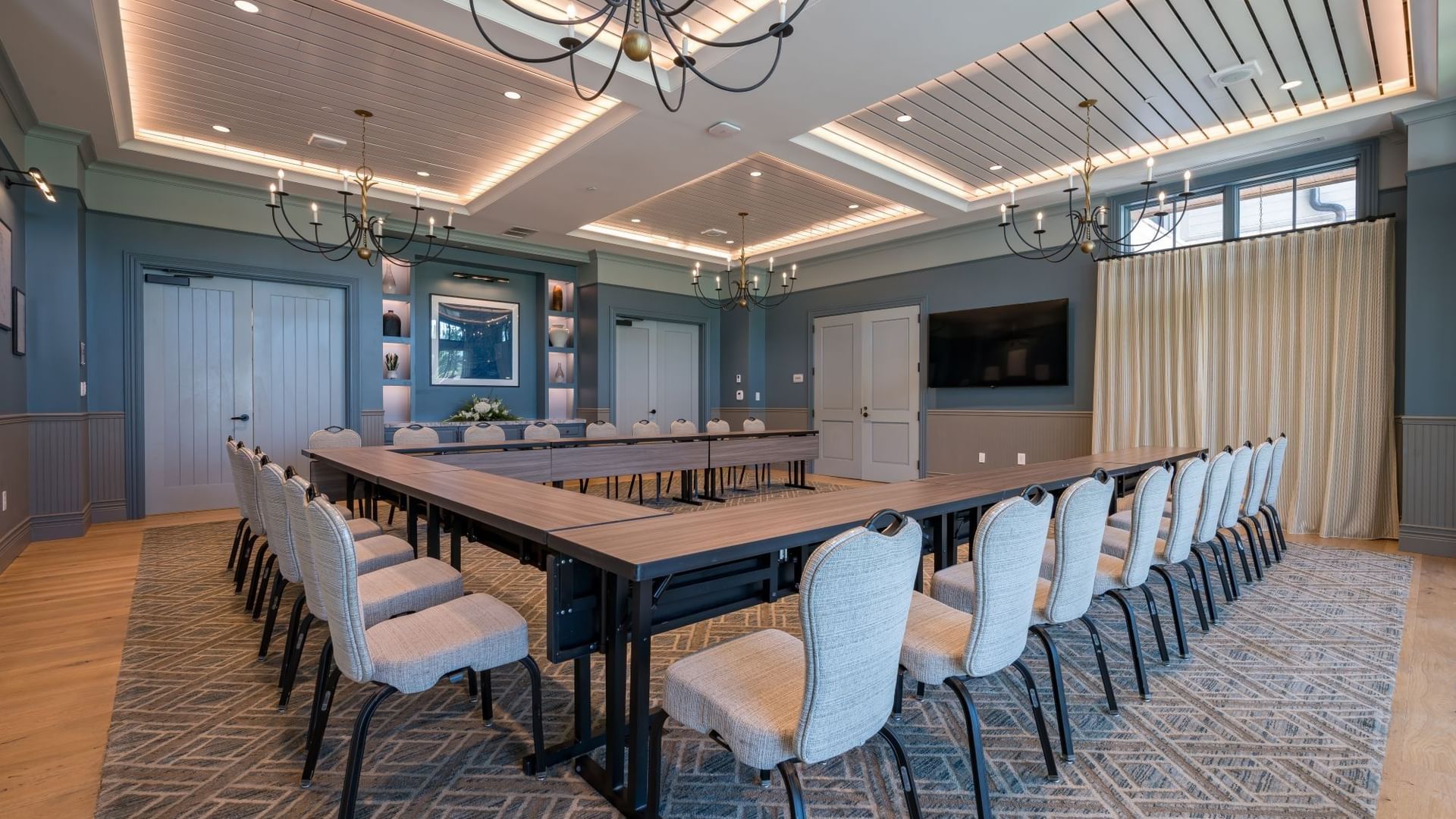 Spacious Club Room with long conference table, upholstered chairs, and elegant chandeliers at Camp Creek Inn, Inlet Beach