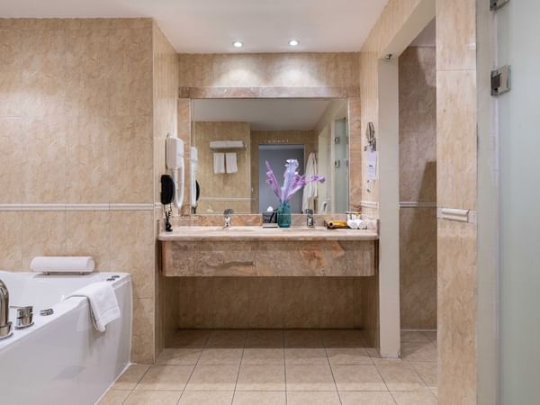 Interior of a bathroom with vanity and bathtub at Warwick Hotel Al Jubail