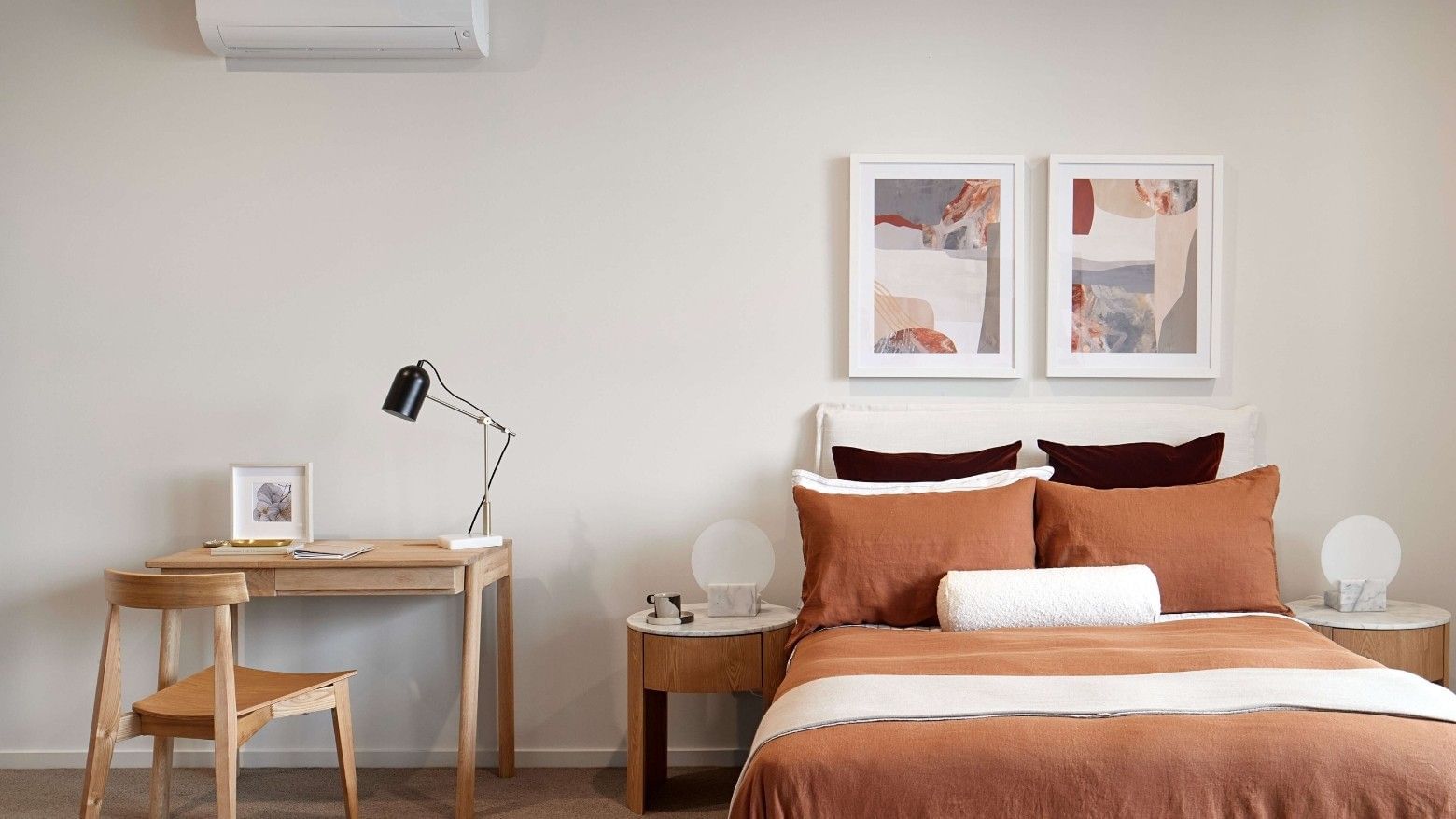 Cozy bedroom in Melbourne with brown bedding, a desk, a chair, two nightstands, and two framed pictures on the wall.