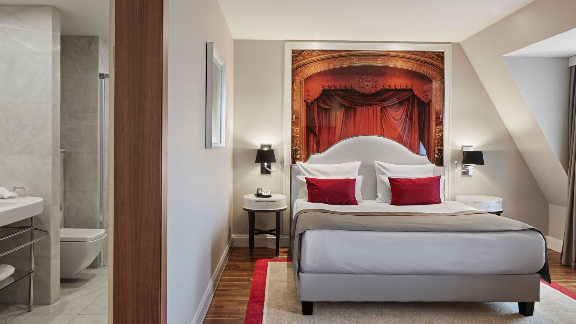 Junior Suite mit Holzboden und Nachttisch am Bett im Titanic Gendarmenmarkt Berlin.