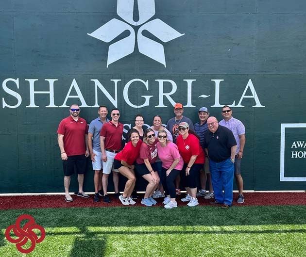 People posing by the hotel sign on a wall at Shangri-La Monkey Island