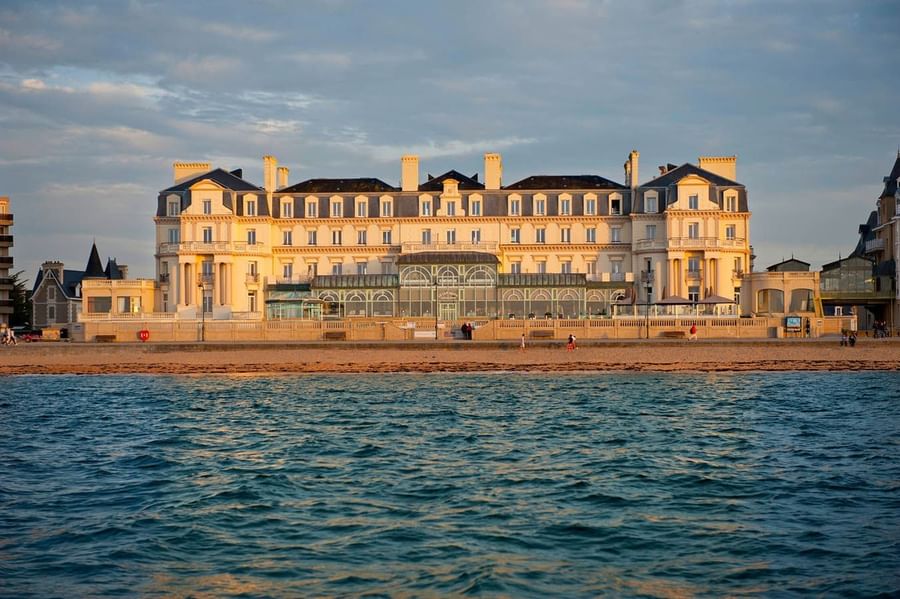 The grand historic facade of a beachfront hotel viewed at Le Grand Hôtel des Thermes