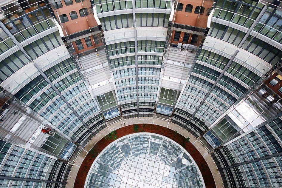 Moderner Innenhof im Wiener Gasometer mit Glasdach, kreisförmiger Architektur und urbanem Design.