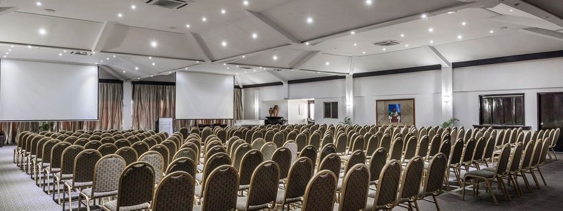 Talanoa Hall with gold-frame chairs by white walls under a lit canopy at Warwick Fiji Resort and Spa