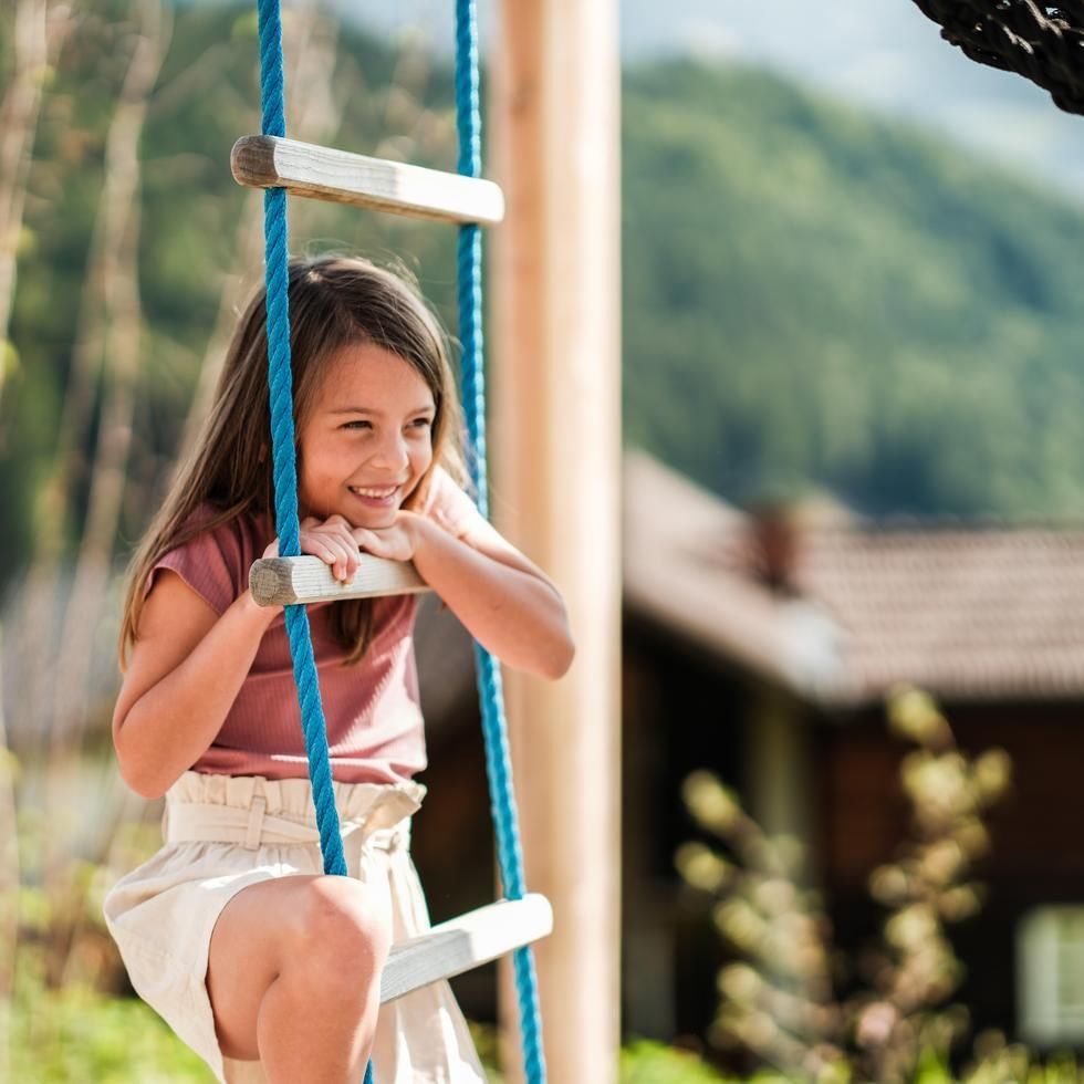 Smiling girl enjoying the rope ladder outdoors at Falkensteiner Family Resort Sicily
