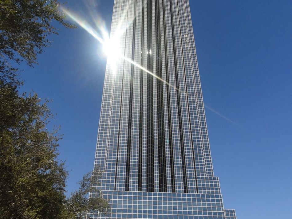 Williams Tower near Granduca Houston, shining in sunlight against a clear blue sky