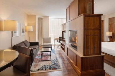 Fireplace by TV lounge area with wooden floors in Executive Suites at Portland Harbor Hotel
