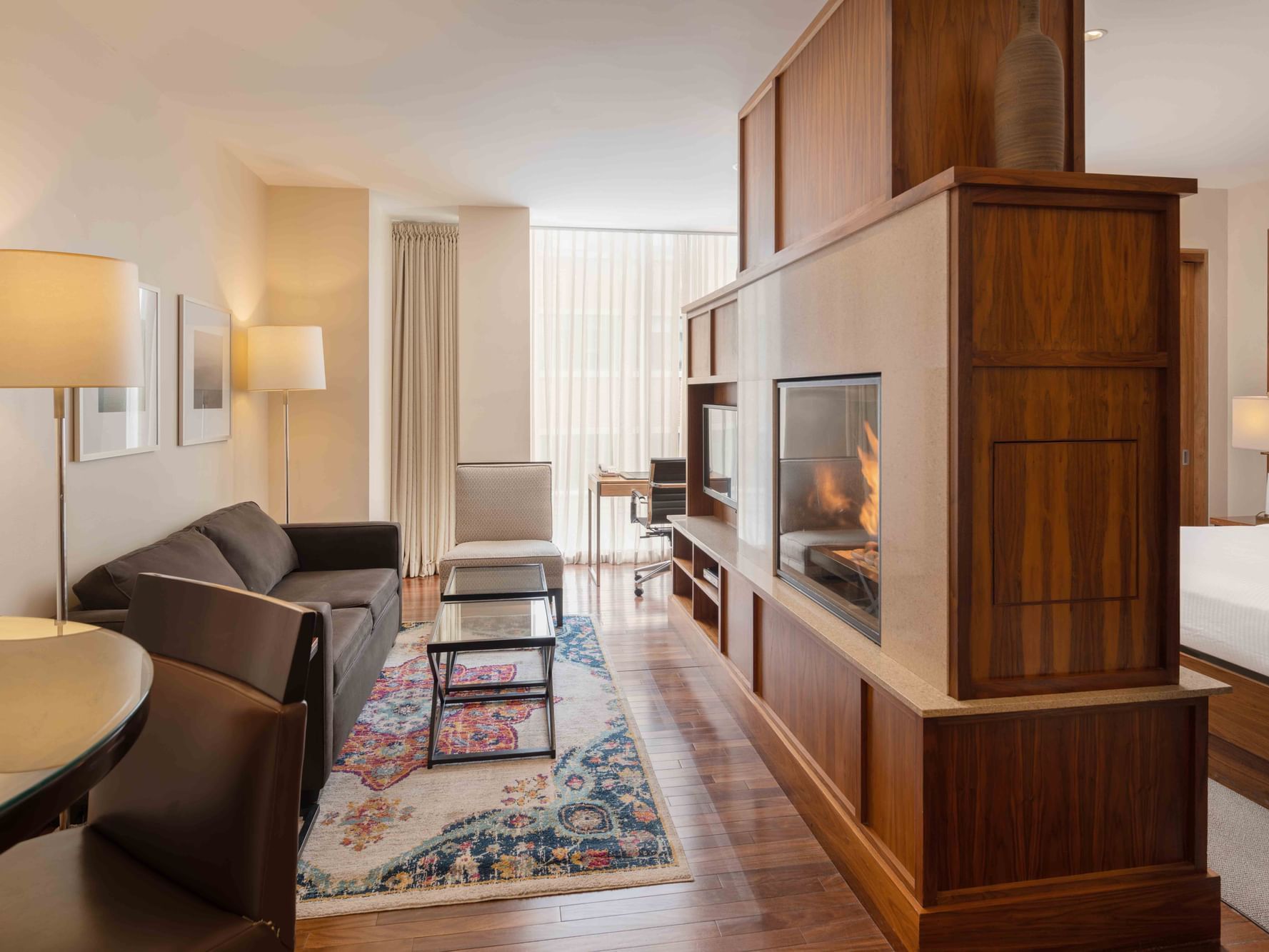 Fireplace by TV lounge area with wooden floors in Executive Suites at Portland Harbor Hotel