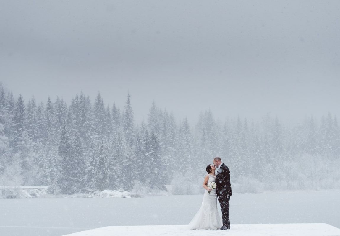 Wedded couple posing in the snow at Nita Lake Lodge