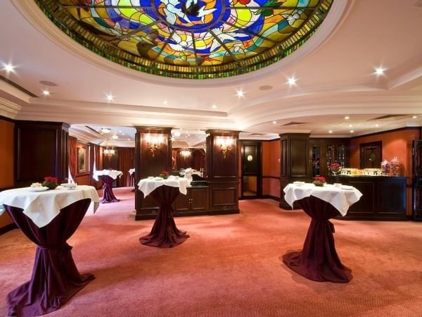 Elegante balzaal met ronde tafels en kristallen plafondkroonluchter bij Warwick Grand-Place.