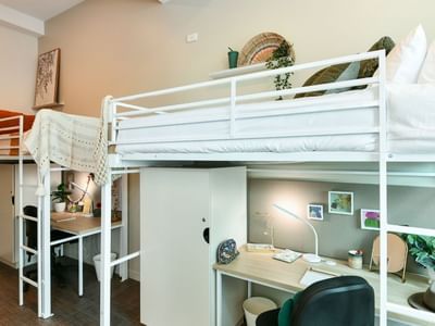 Triple Loft Room with three loft bunk beds with desks underneath at UniLodge Herston.