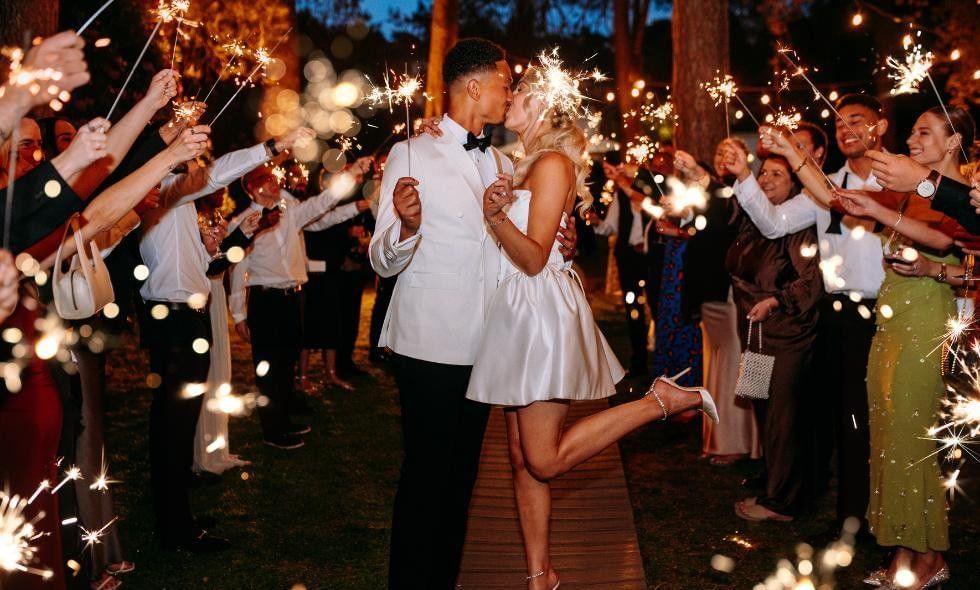 Bride and groom kissing surrounded by sparklers as we promote our surrey wedding fair at Gorse Hill