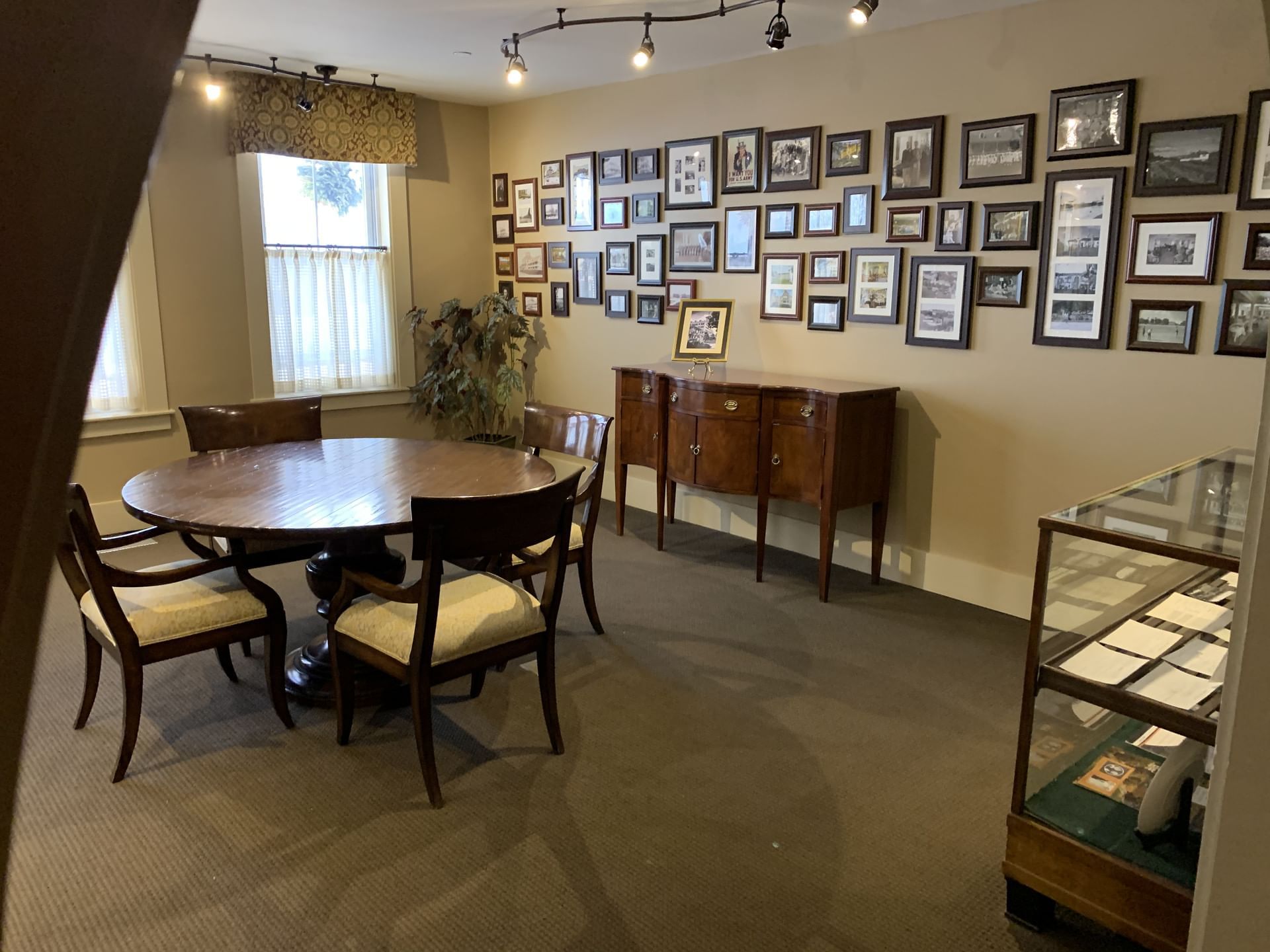 Round table and chairs by a gallery wall of framed photos in the History room at Mountain View Grand Resort & Spa