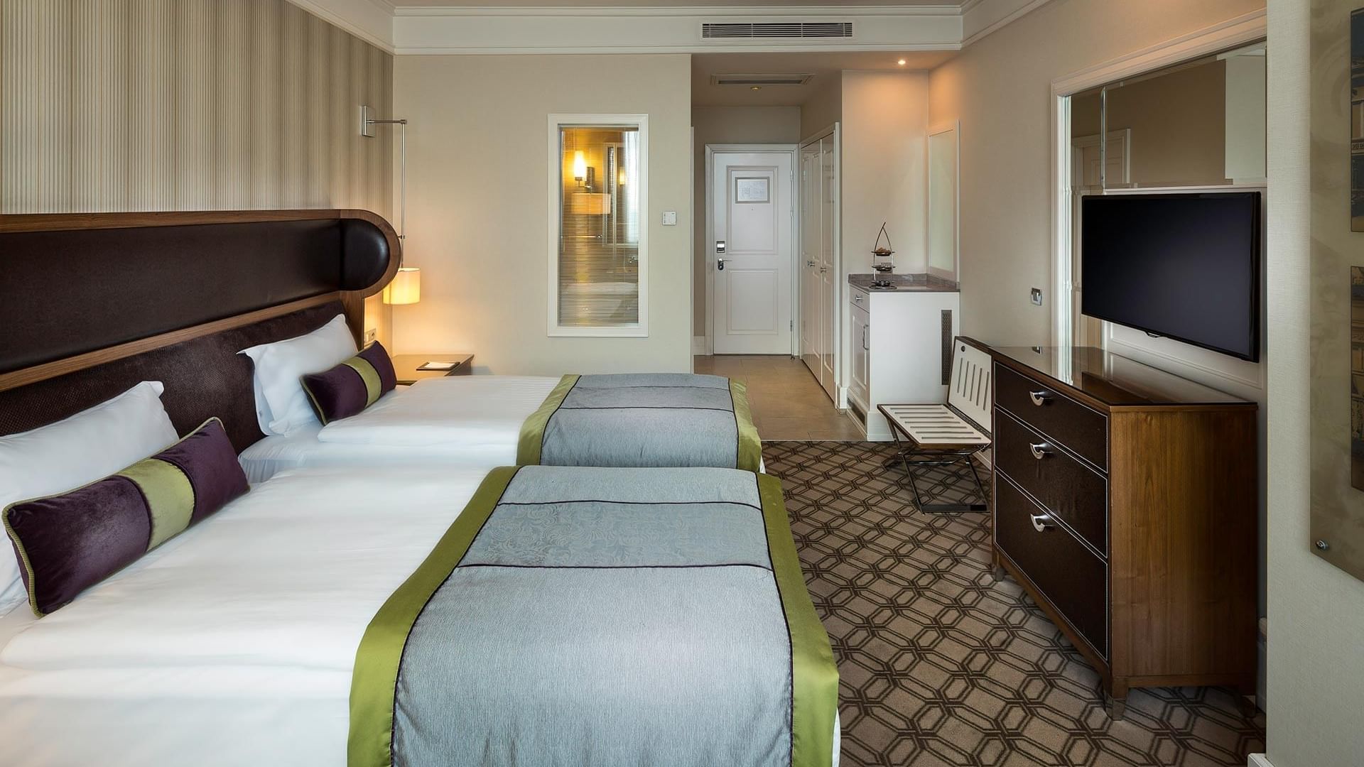 Titanic Port Bakırköy’de, iki yatak, üzerinde televizyon bulunan bir şifonyer ve bir koltukla donatılmış konforlu bir Superior oda.