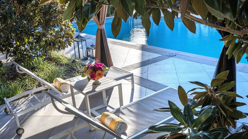 Swimming pool area with lounge chairs and plants at Warwick Melrose in Dallas.