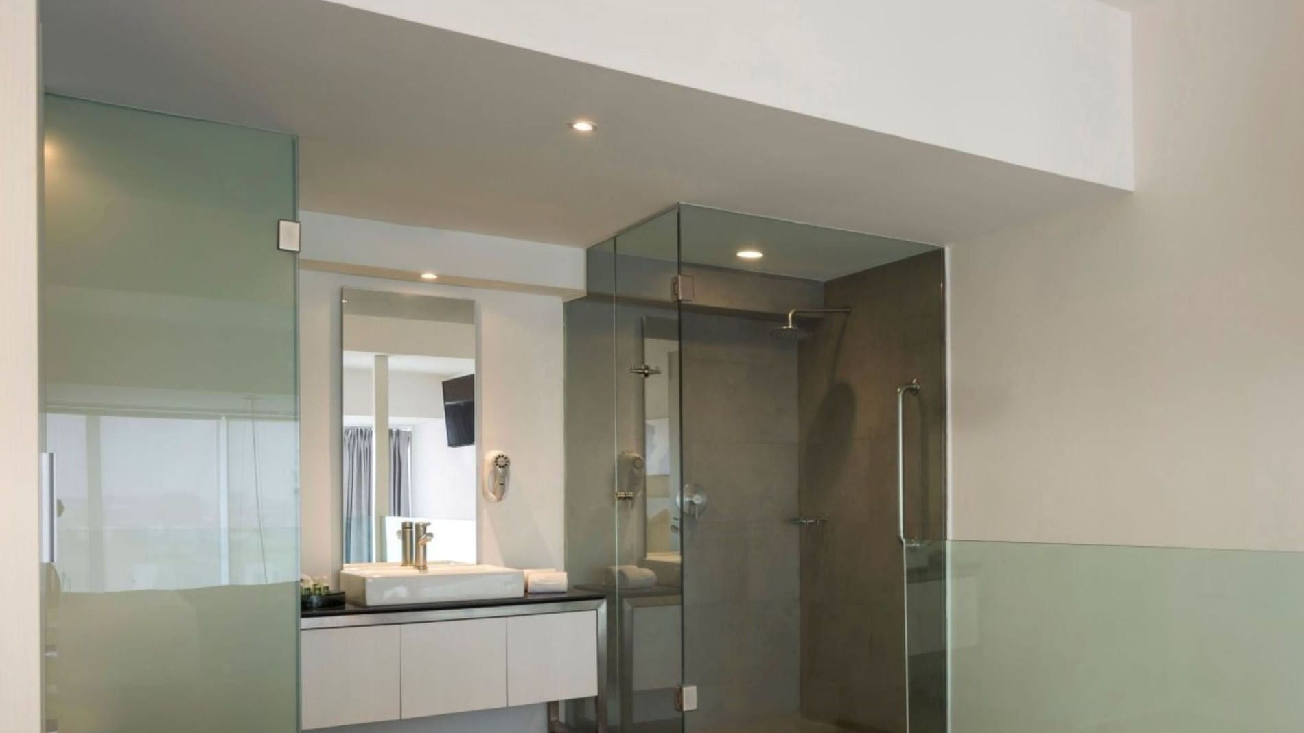 Queen Loft Bed bathroom with a glass shower stall and sleek white vessel sink at Camino Real Puebla Angelopolis