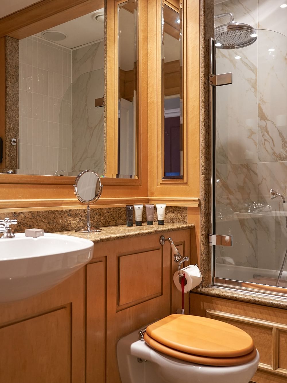 Elegant bathroom with marble and wood features, and a bathtub at The Capital Hotel, Apartments & Townhouse