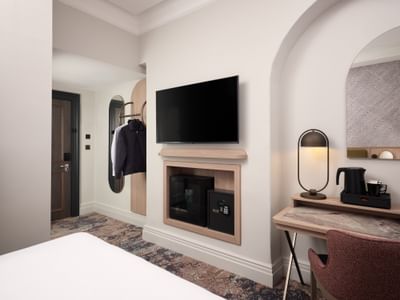 Modern desk area in a Standard Double Room at The Met Hotel Leeds, England, with TV, minibar, safe, and coffee station