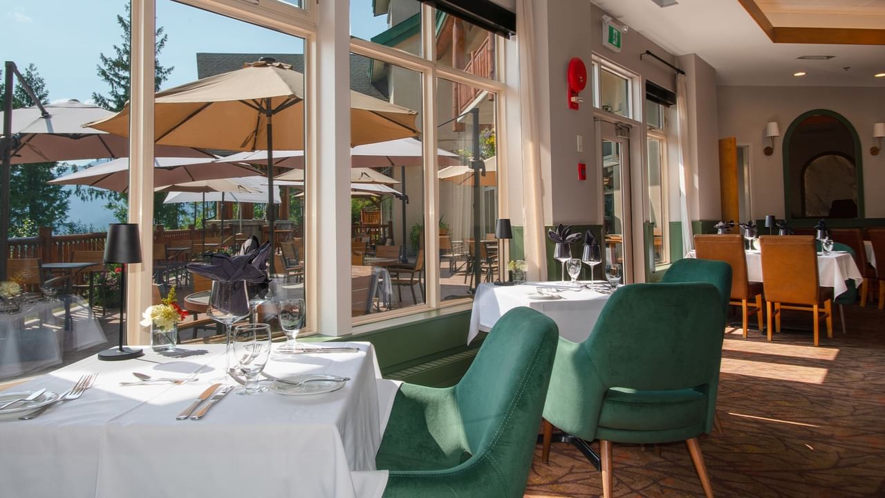 Hotel restaurant with dining table, chairs and patio